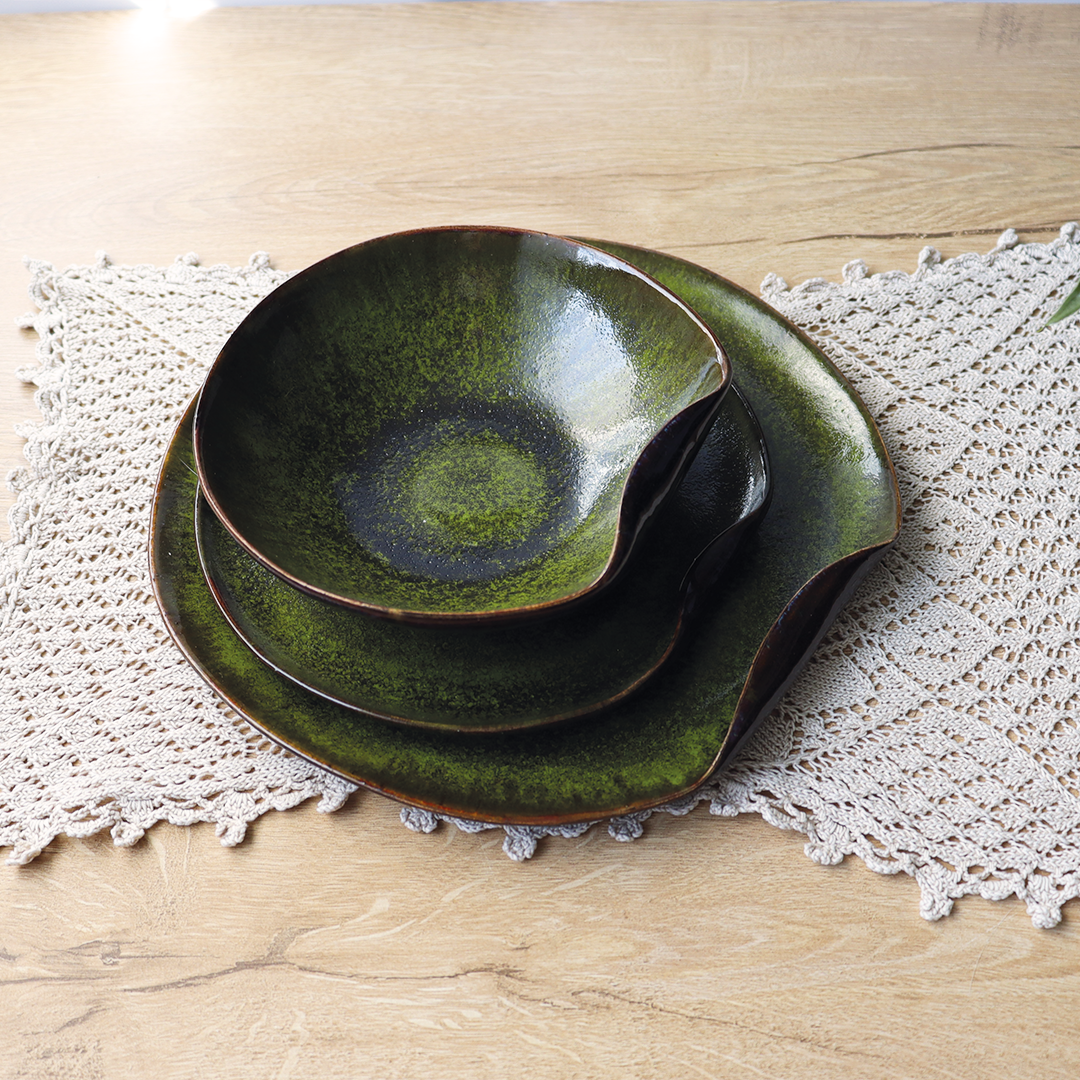 Ceramiczne naczynia z kolekcji Leśny Mech, ręcznie wykonane, o oryginalnym zagiętym brzegu, pokryte szkliwem o barwach zieleni leśnego mchu i brązu z błękitnymi przebłyskami