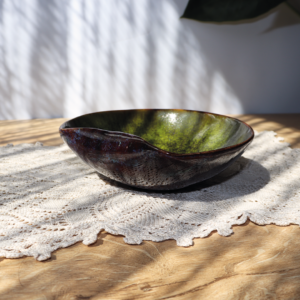 Ceramiczna miska z kolekcji Leśny Mech, ręcznie wykonana, o oryginalnym zagiętym brzegu, pokryta szkliwem o barwach zieleni leśnego mchu i brązu z błękitnymi przebłyskami