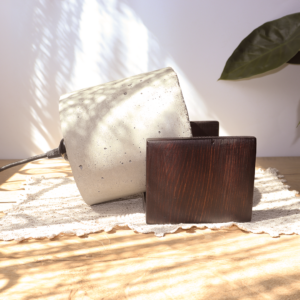 Lampka wykonana z betonu na kształt halogenu na drewnianej podstawce.