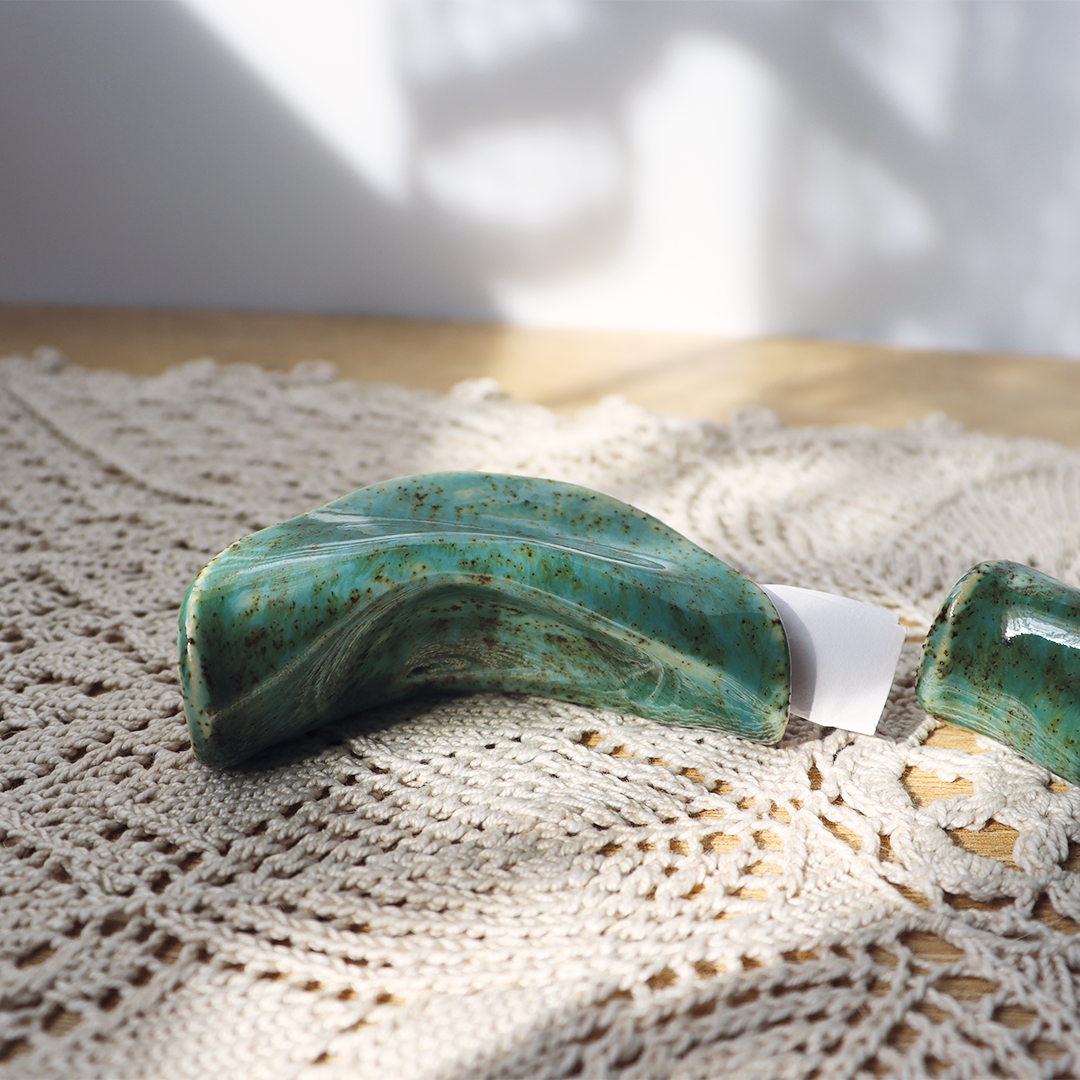 Ceramiczna ozdoba wykonana na wzór chińskiego ciasteczka na wróżby w kolorze kremowym w kolorach patyny