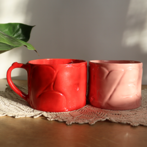 Ręcznie wykonane ceramiczne kubeczki o pojemności 600 ml, ozdobione wypukłym napisem LOVE w czerwonym lub różowym kolorze.