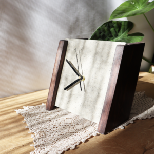 Ręcznie wykonany betonowy zegar stojący na drewnianych podstawach