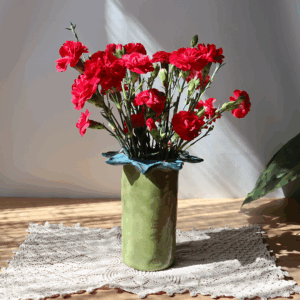 Ręcznie robiony ceramiczny wazon wykonany na kształt kwiatka z niebieskimi płatkami na brzegu